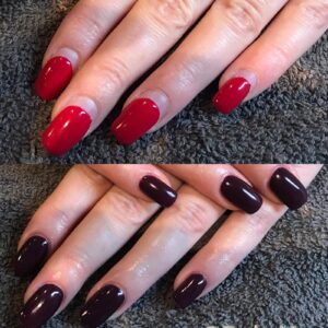 Rode en paarse gelnagels op een handdoek.